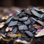 Wood ash and paper ash mixed into dark compost pile for gardening